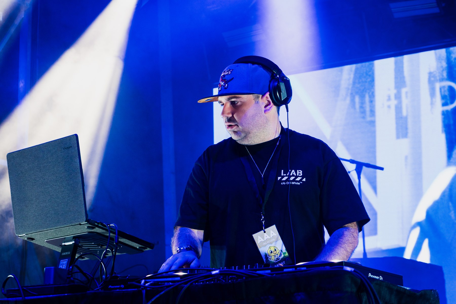 Dylan DJing in headphones under blue and white stage lights