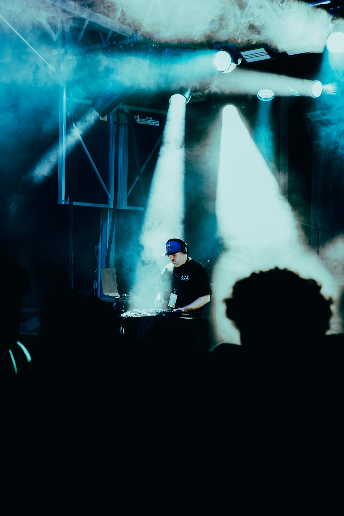 DJ performance beneath dramatic overhead spotlights